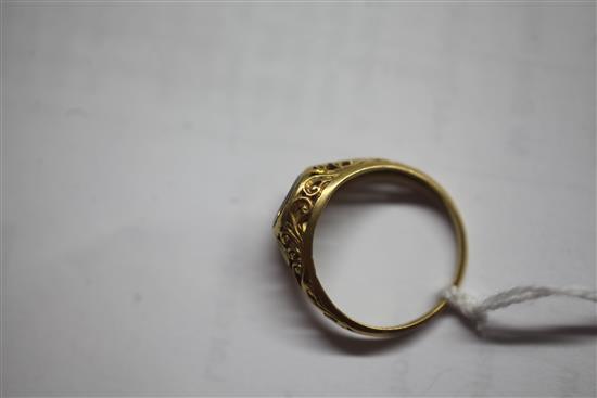 An antique scroll-pierced yellow metal ring set with an oval diamond,
